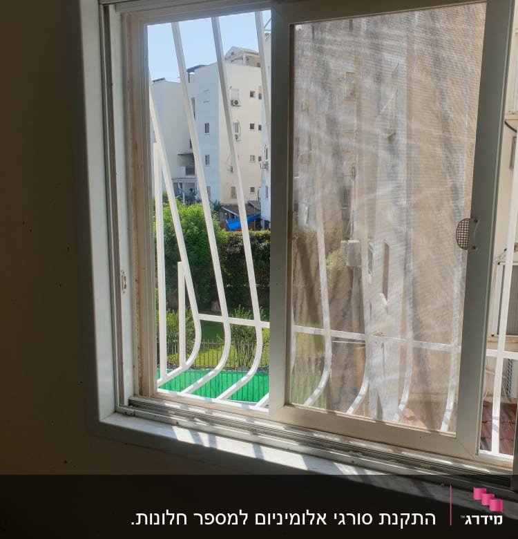 חלון עם מסגרת לבנה וסורגים לבנים